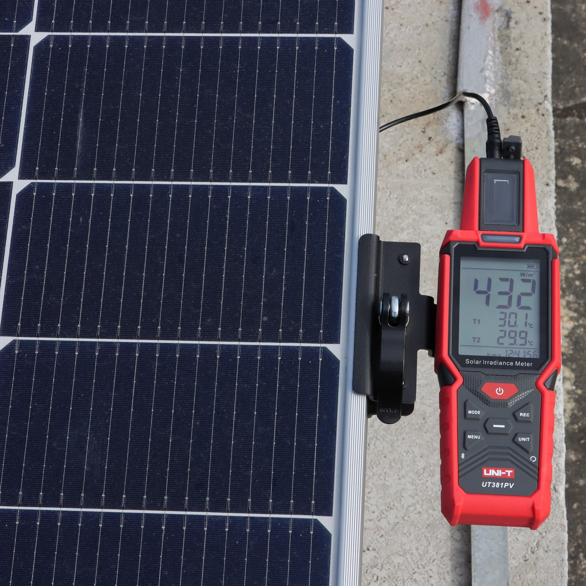UNI-T UT381PV on its mounting bracket at the edge of a solar module